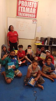 Várias crianças do projeto itamar lendo livros